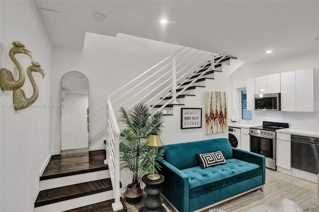 staircase featuring washer / dryer and wood-type flooring