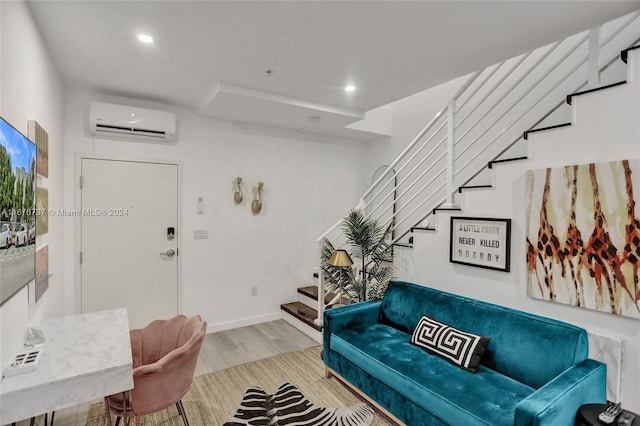 living room with a wall mounted AC and light hardwood / wood-style flooring