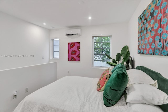 bedroom featuring an AC wall unit and multiple windows