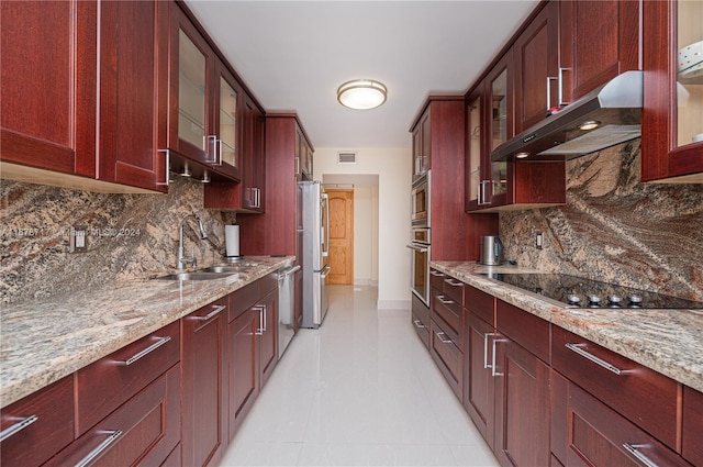 kitchen with light stone counters, backsplash, and appliances with stainless steel finishes