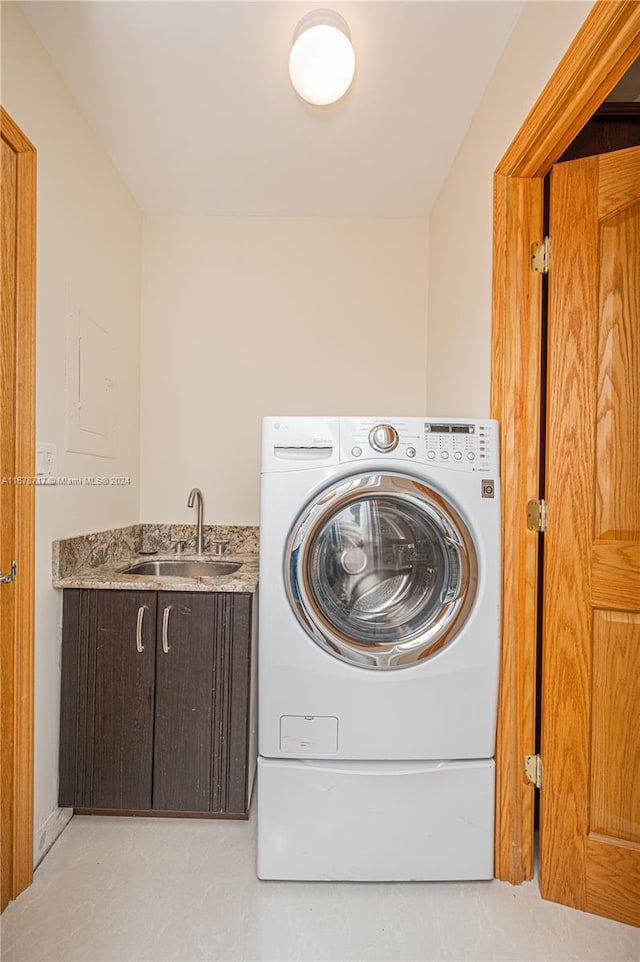 laundry room with cabinets, sink, and washer / clothes dryer