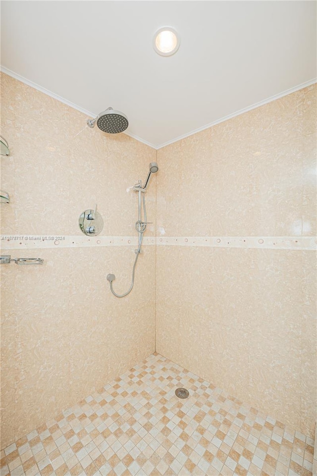 bathroom with a tile shower and ornamental molding