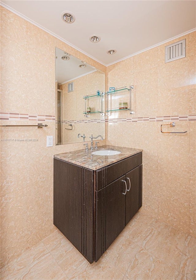 bathroom with vanity, crown molding, and tile walls