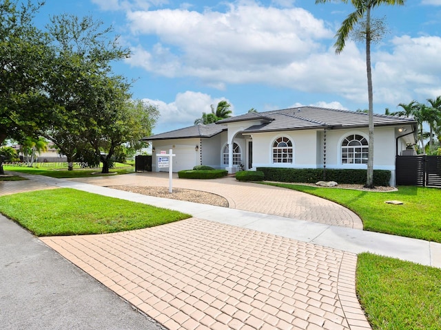 ranch-style house featuring a front yard and a garage