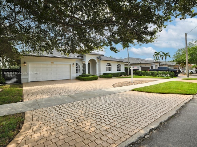 ranch-style home featuring a front lawn and a garage