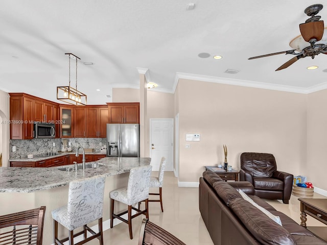 kitchen with tasteful backsplash, light stone counters, sink, crown molding, and stainless steel appliances