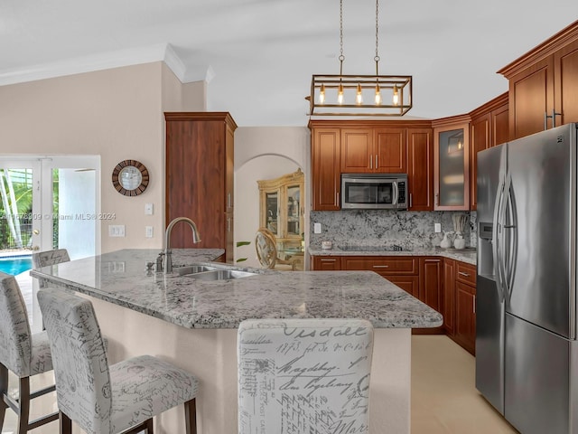 kitchen featuring tasteful backsplash, sink, kitchen peninsula, stainless steel appliances, and a breakfast bar