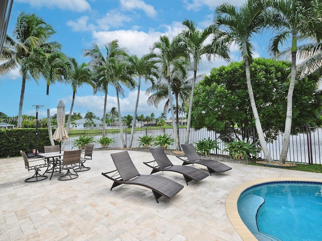 view of pool featuring a patio area and a water view