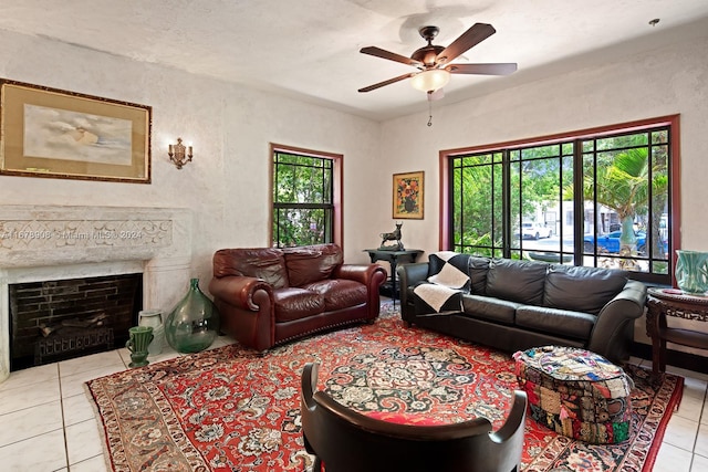 living room with a wealth of natural light, ceiling fan, a fireplace, and light tile patterned floors