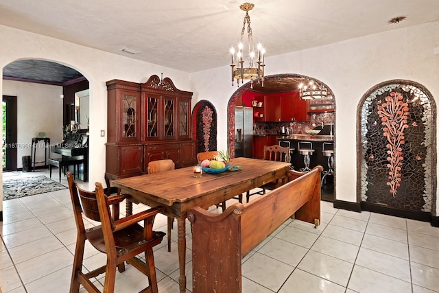 dining area featuring a notable chandelier and light tile patterned flooring