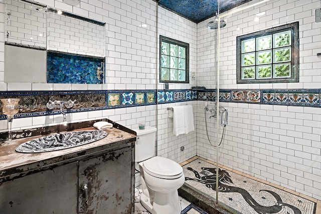 bathroom featuring a shower with door, toilet, tile walls, and vanity