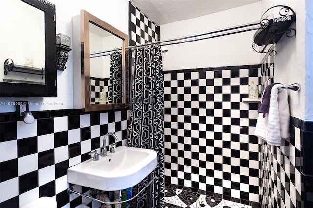 bathroom with tile walls, sink, and a shower with shower curtain