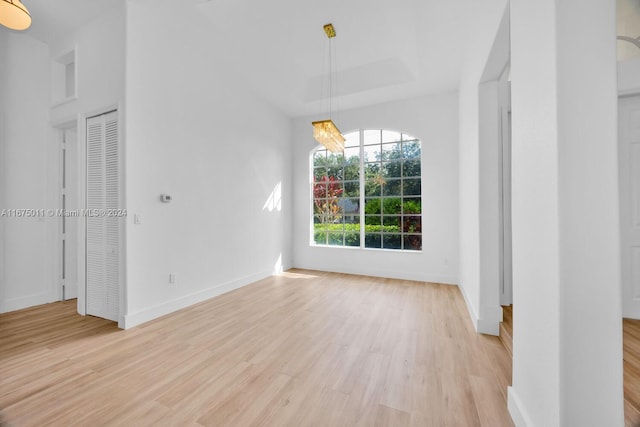 unfurnished dining area with light hardwood / wood-style floors and a notable chandelier