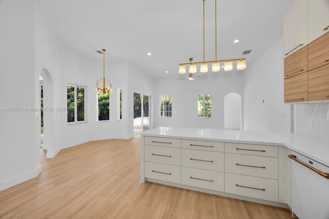 kitchen featuring white cabinetry, white dishwasher, light wood-type flooring, and hanging light fixtures