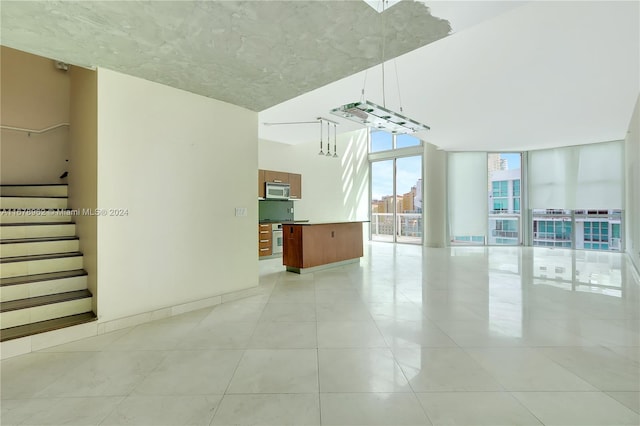 unfurnished living room featuring light tile patterned floors and floor to ceiling windows