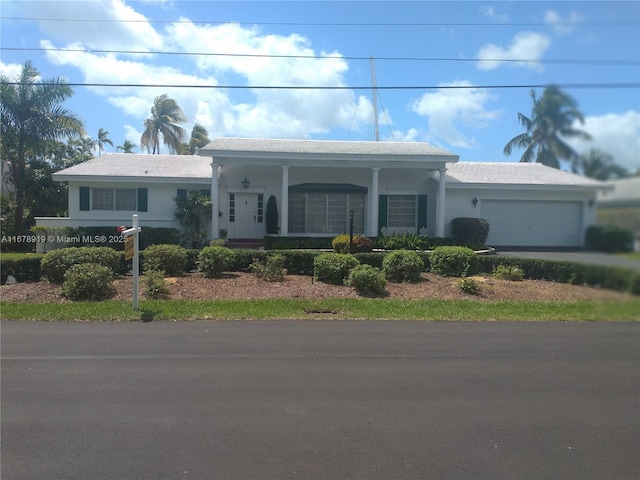 3440 NE 170th St, North Miami Beach, FL 33160 - view of front of property with stucco siding, driveway, a porch, and a garage