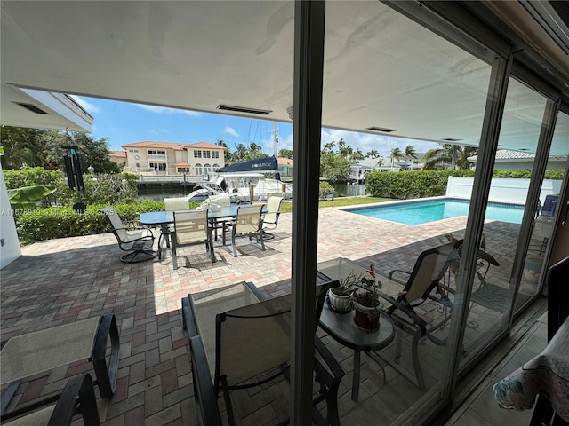 3440 NE 170th St, North Miami Beach, FL 33160 - view of swimming pool featuring outdoor dining space, a fenced in pool, a patio, and a water view