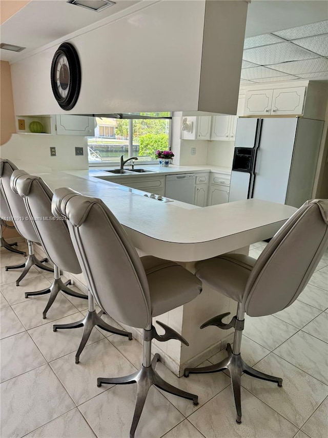 dining room featuring sink, crown molding, and light tile patterned floors