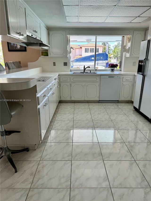 kitchen with white cabinets, sink, and white appliances