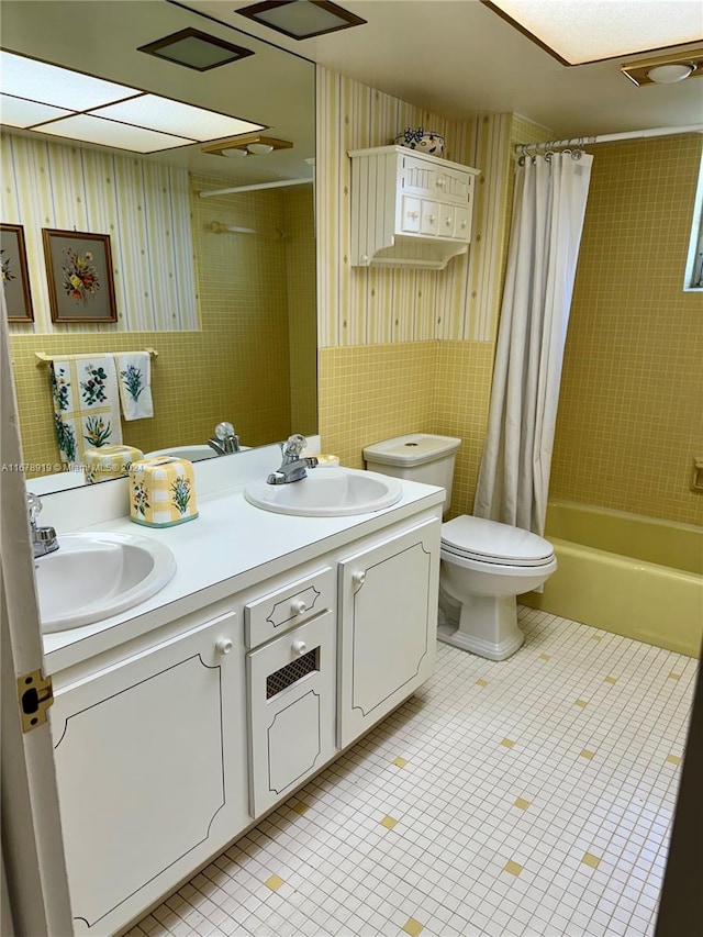 full bathroom featuring toilet, shower / tub combo with curtain, vanity, and tile walls