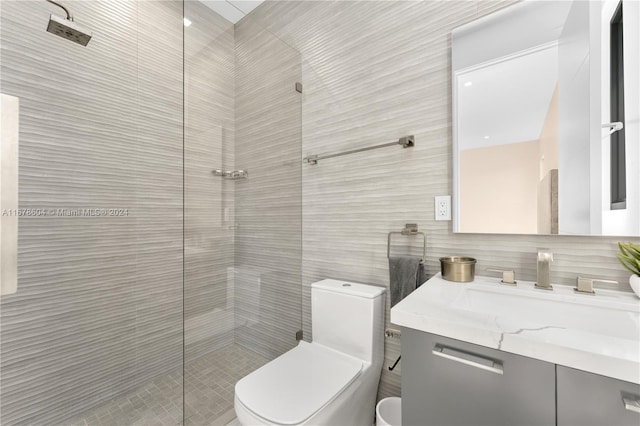 bathroom featuring vanity, a shower, toilet, tile walls, and tasteful backsplash