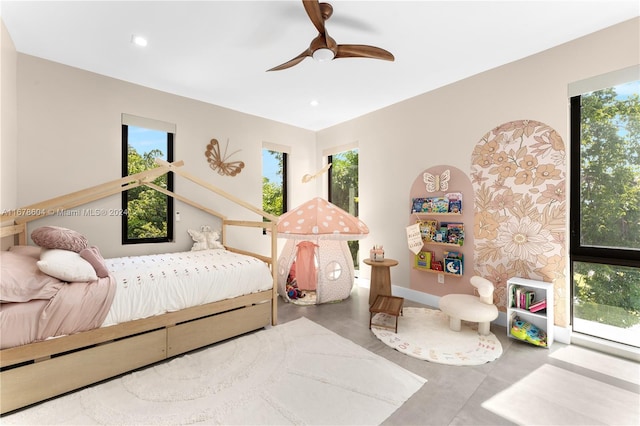 bedroom with concrete flooring, multiple windows, and ceiling fan