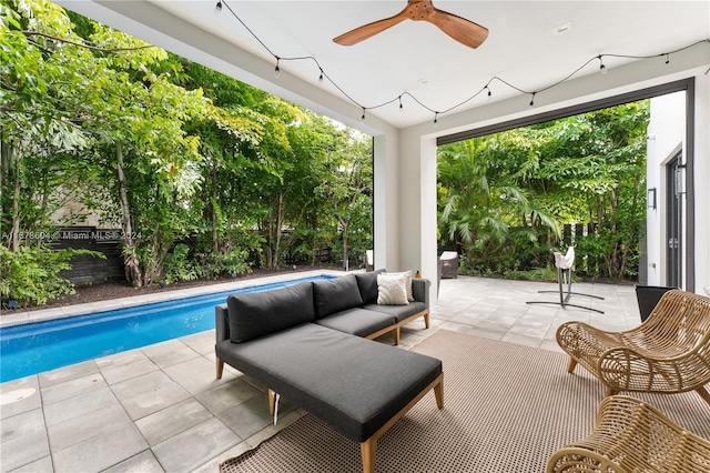 view of pool with outdoor lounge area, ceiling fan, and a patio area