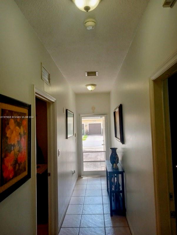 corridor featuring light tile patterned flooring