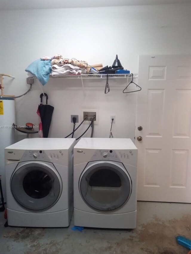 clothes washing area featuring water heater and washing machine and clothes dryer