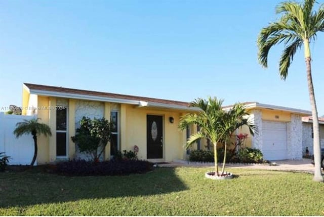 single story home featuring a garage and a front lawn