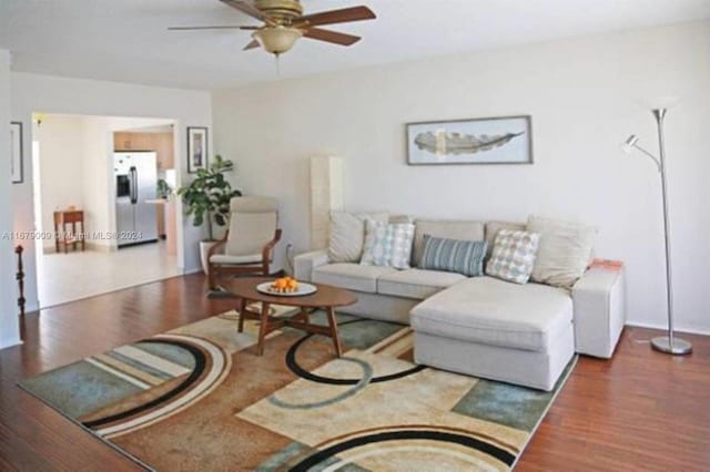 living room featuring wood-type flooring and ceiling fan