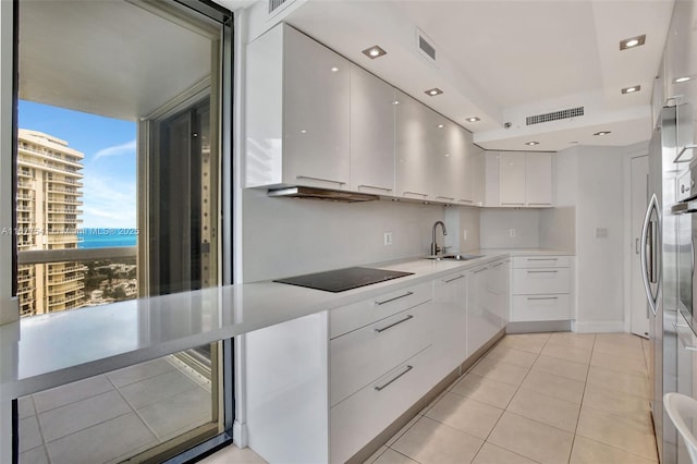 20185 E Country Club Dr Unit 2209, Aventura, FL 33180 - kitchen with black electric cooktop, modern cabinets, a sink, white cabinetry, and light tile patterned floors