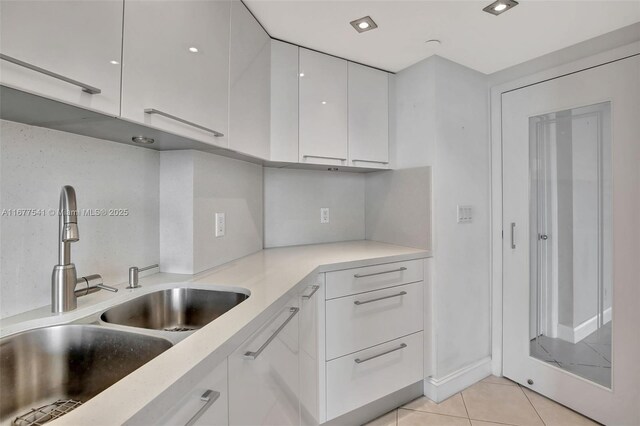 20185 E Country Club Dr Unit 2209, Aventura, FL 33180 - kitchen with a sink, white cabinets, light tile patterned floors, modern cabinets, and light countertops