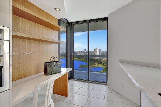 interior space with a water view and a wall of windows