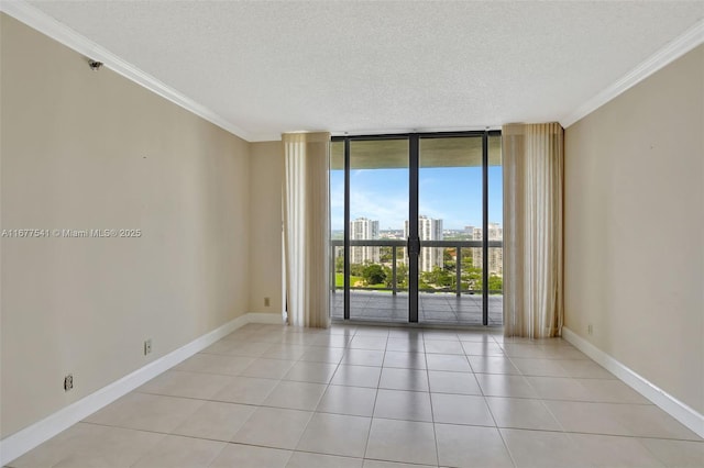 empty room with floor to ceiling windows, light tile patterned flooring, a textured ceiling, and ornamental molding