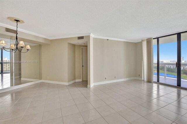 20185 E Country Club Dr Unit 2209, Aventura, FL 33180 - spare room featuring a textured ceiling, healthy amount of natural light, a chandelier, light tile patterned floors, and a wall of windows