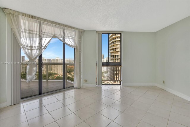 20185 E Country Club Dr Unit 2209, Aventura, FL 33180 - unfurnished room with baseboards, a textured ceiling, tile patterned floors, and a wall of windows