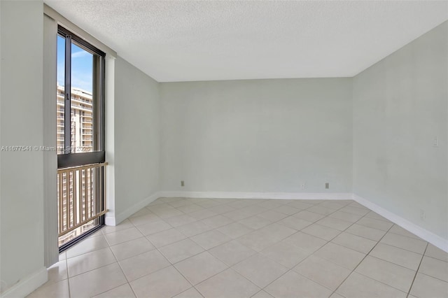 tiled spare room with a textured ceiling