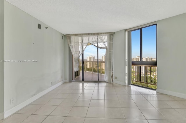 20185 E Country Club Dr Unit 2209, Aventura, FL 33180 - spare room featuring a textured ceiling, baseboards, tile patterned floors, floor to ceiling windows, and a view of city