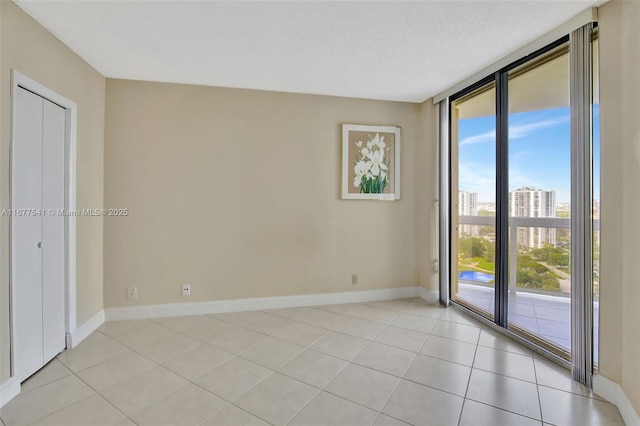 tiled spare room featuring expansive windows