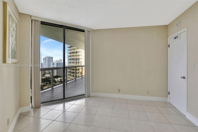 unfurnished room featuring light tile patterned floors, a textured ceiling, and expansive windows