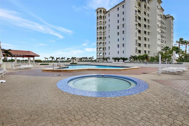 view of swimming pool featuring a gazebo, a community hot tub, and a patio