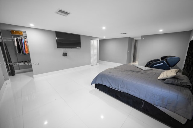 tiled bedroom with a spacious closet and a closet