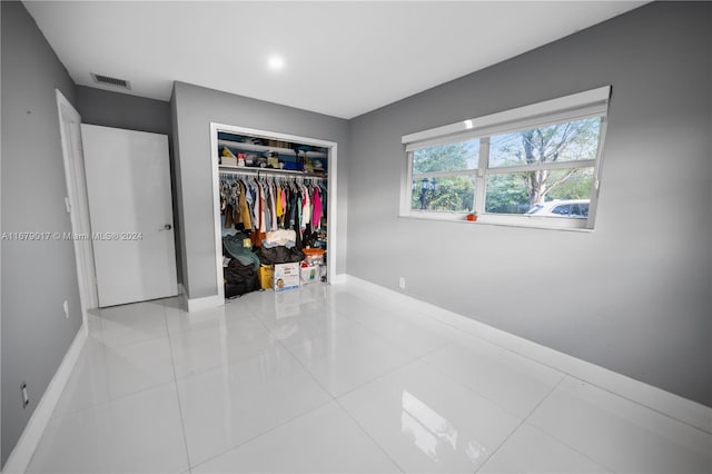 tiled bedroom featuring a closet