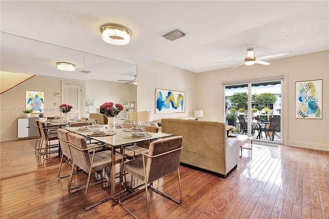 dining space with a textured ceiling, wood-type flooring, and ceiling fan