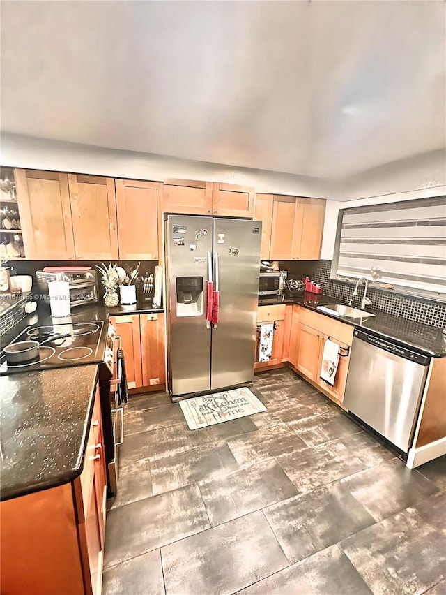 kitchen with stainless steel appliances, dark stone counters, and sink