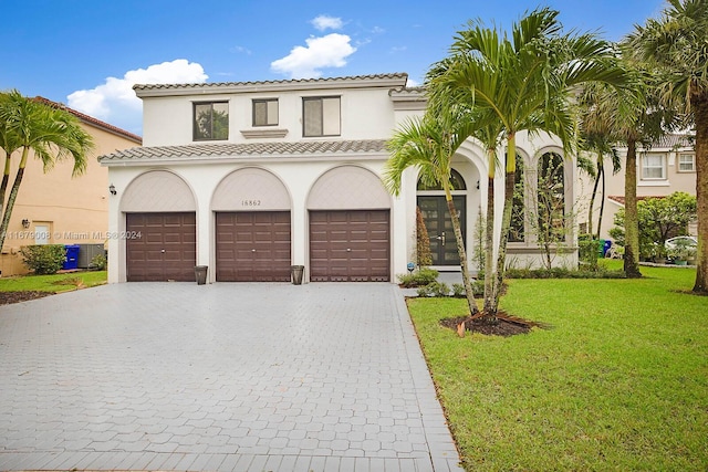 mediterranean / spanish-style house with a front yard and a garage