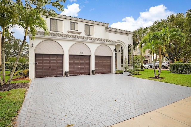 mediterranean / spanish house featuring a front lawn and a garage