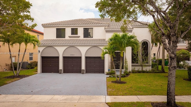 mediterranean / spanish home with a front yard and a garage