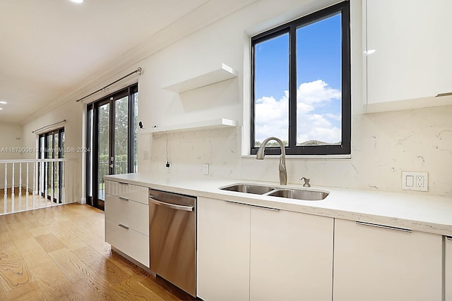 kitchen with stainless steel dishwasher, sink, decorative backsplash, and a wealth of natural light